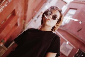 Girl with short red hair and mirror sunglasses smoking cigarette photo