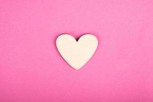 wooden heart on pink background, valentines day love symbol photo