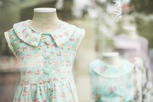 vestido de moda de niña joven en el escaparate de la moda de ropa infantil foto