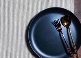 Empty plate with spoon and fork on Napery background, table setting photo