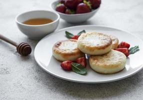 Tortitas de requesón, buñuelos de ricotta en placa de cerámica foto