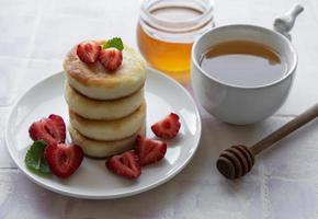 Tortitas de requesón, buñuelos de ricotta en placa de cerámica foto