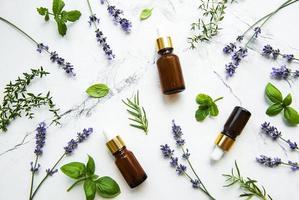 Bottles of essential oils with herbs and flowers photo