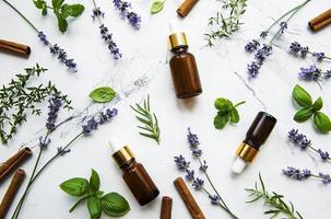 Bottles of essential oils with herbs and flowers