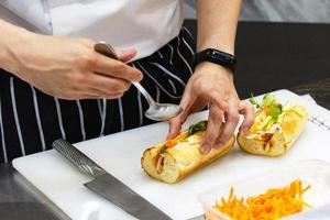 chef prepara sándwich en la cocina foto