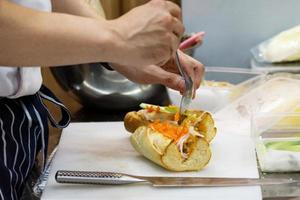 chef prepara sándwich en la cocina foto