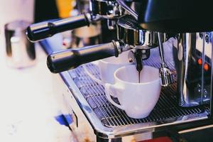 Espresso shot de máquina de café en la cafetería. foto
