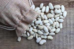 Beans in a bag on a wooden background photo