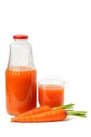 Glass bottle and a glass of carrot juice with whole carrots photo