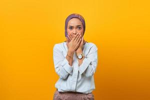 Portrait of shocked Asian woman while covered mouth with hands photo