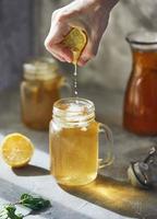 Cold glass of iced tea with ice cubes, isolated on white photo