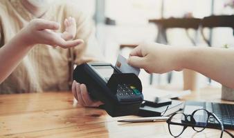 Close-up of asian customer using his credit card to swipe with EDC photo