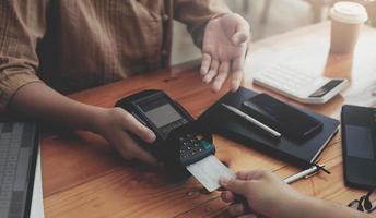 Close-up of asian customer using his credit card to swipe with EDC photo