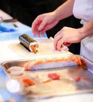 manos de chef preparando comida japonesa, chef haciendo sushi foto