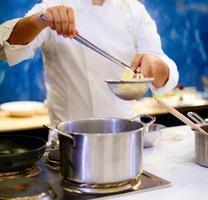 Chef cooking spaghetti in the kitchen photo