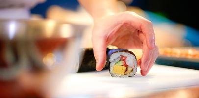 manos de chef preparando comida japonesa, chef haciendo sushi foto