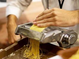 Chef haciendo pasta con una máquina, pasta fresca casera
