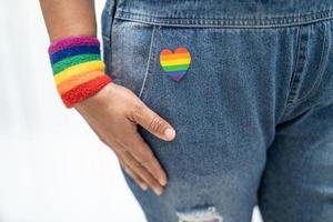 dama asiática con pulseras con la bandera del arco iris, símbolo de lgbt foto