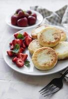 Tortitas de requesón, buñuelos de ricotta en placa de cerámica foto