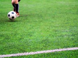 The footballers are competing on the artificial grass turf of school photo