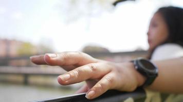 Close up hand of Asian woman on a chair by the river video