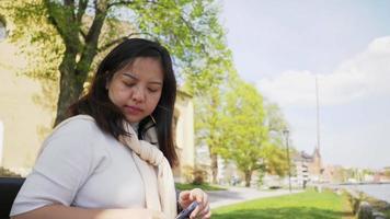 mujer asiática con smartphone y tomando un descanso video