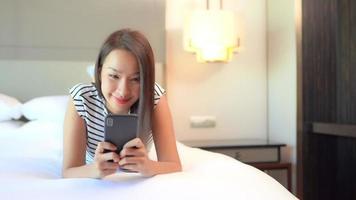 joven, mujer asiática, utilizar, un, smartphone, en cama