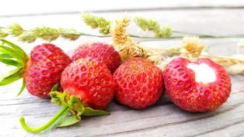 Strawberry close-up with dry yellow sprigs of cereals photo