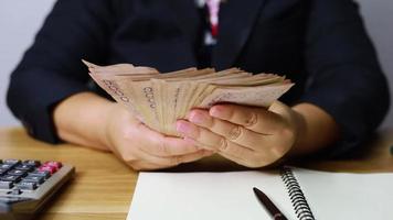 The shooter's hand is counting Thai money. video