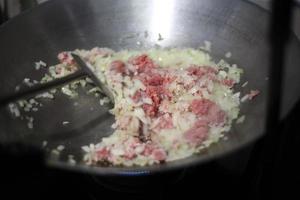 Chef cocinando arroz frito chino con llama en una sartén grande foto