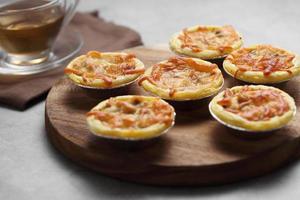 Mini pie from meat and mushrooms in wooden tray photo