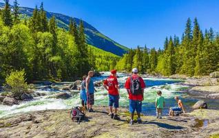 Viken, Noruega 2016- excursionista turistas en el río y la cascada rjukandefossen en hemsedal noruega foto