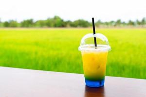Lemonade soda served on table in cafe with paddy rice field background photo