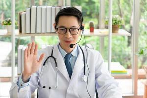 Asian doctor give consult to patient via online video call photo