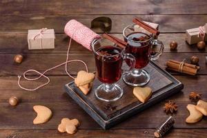 Christmas mulled red wine with spices and fruits on a dark table. photo