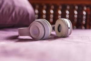 White headphones on purple background. Music concept. photo