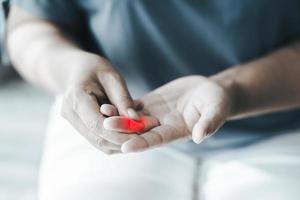 Woman suffer from hand and finger joint pain with red highlight. photo