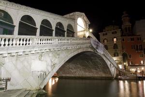 Vista nocturna del puente de Rialto en Venecia Italia foto