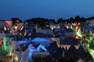 Vista nocturna de las típicas casas trulli en Alberobello Italia foto