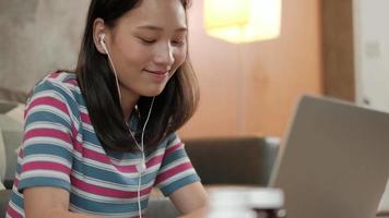 mujer asiática que usa la computadora portátil para el trabajo desde casa y el aprendizaje en línea. video