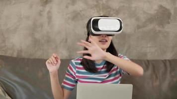 donna asiatica con auricolare vr, guardando la simulazione virtuale 3d. video