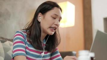 mulher asiática usando laptop para trabalhar em casa e aprendizagem on-line. video