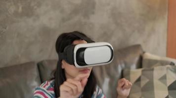 mulher asiática com fone de ouvido vr, assistindo a simulação virtual 3d. video