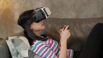 Asian woman with VR glasses headset and game joys controller. video