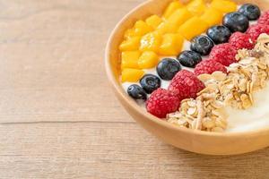 Homemade yogurt bowl with raspberry, blueberry, mango and granola photo