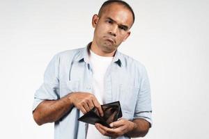 Hombre sujetando su billetera vacía sobre fondo blanco. foto