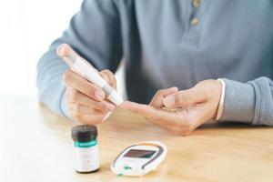 Man use lancet on finger for check blood sugar level by glucose meter