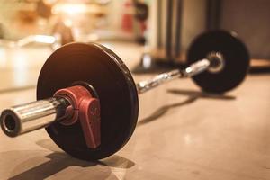 Set of black heavy steel barbells on fitness sport gym floor photo