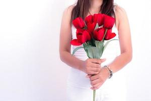 Mujer sosteniendo flor rosa roja sobre fondo blanco. foto