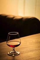 glass of french cognac brandy on cozy bar table detail photo